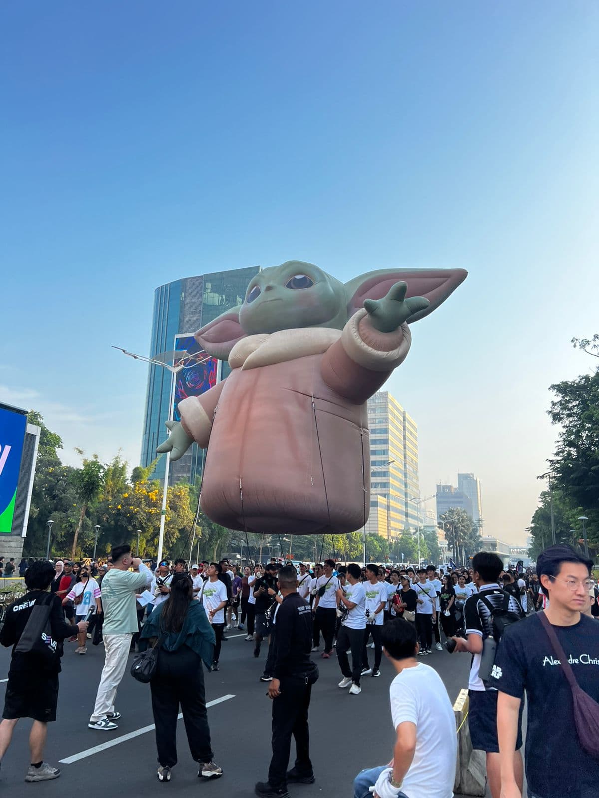 为 Disney Indonesia 制作的大型 Grogu 氦气充气装置,飘浮在街头巡游人群上方