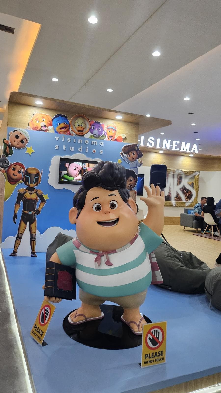 为 Visinema Studios 制作的动画电影《Jumbo》角色 Don 雕像,在工作室展台上挥手并手持一本书